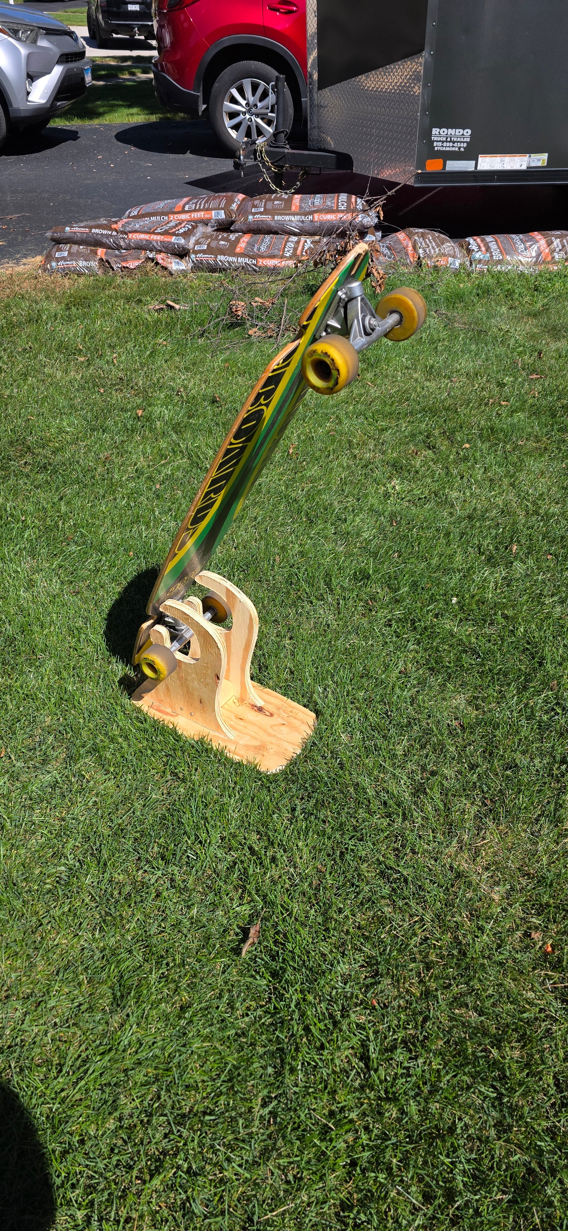 Construction Claw holding a longboard outside, displaying bottomside