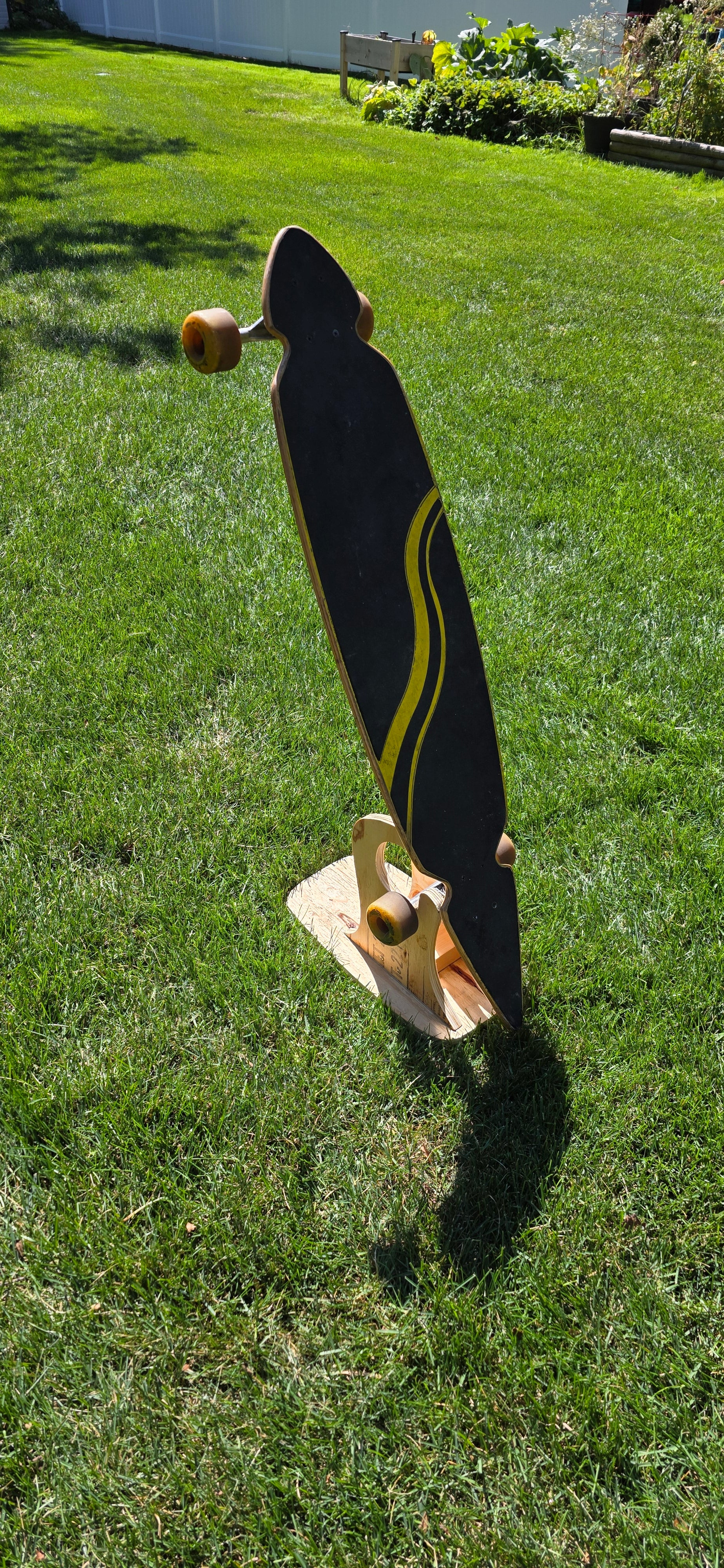 Construction Claw holding a longboard outside, displaying topside