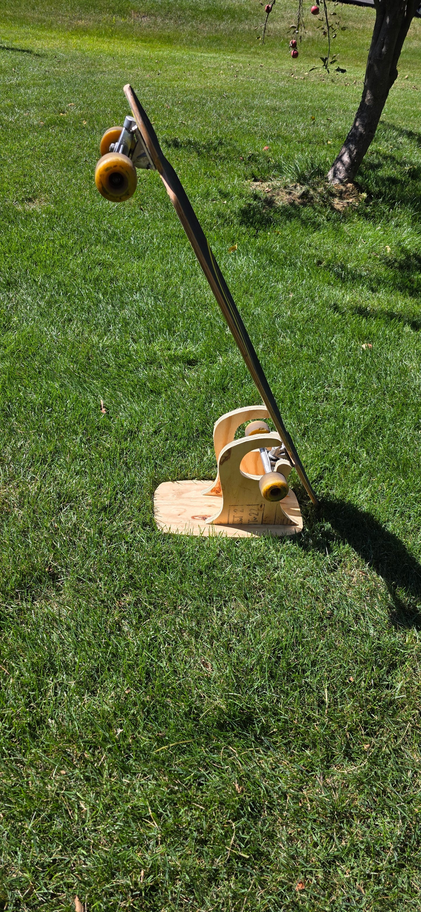 Construction Claw holding a longboard outside, displaying side