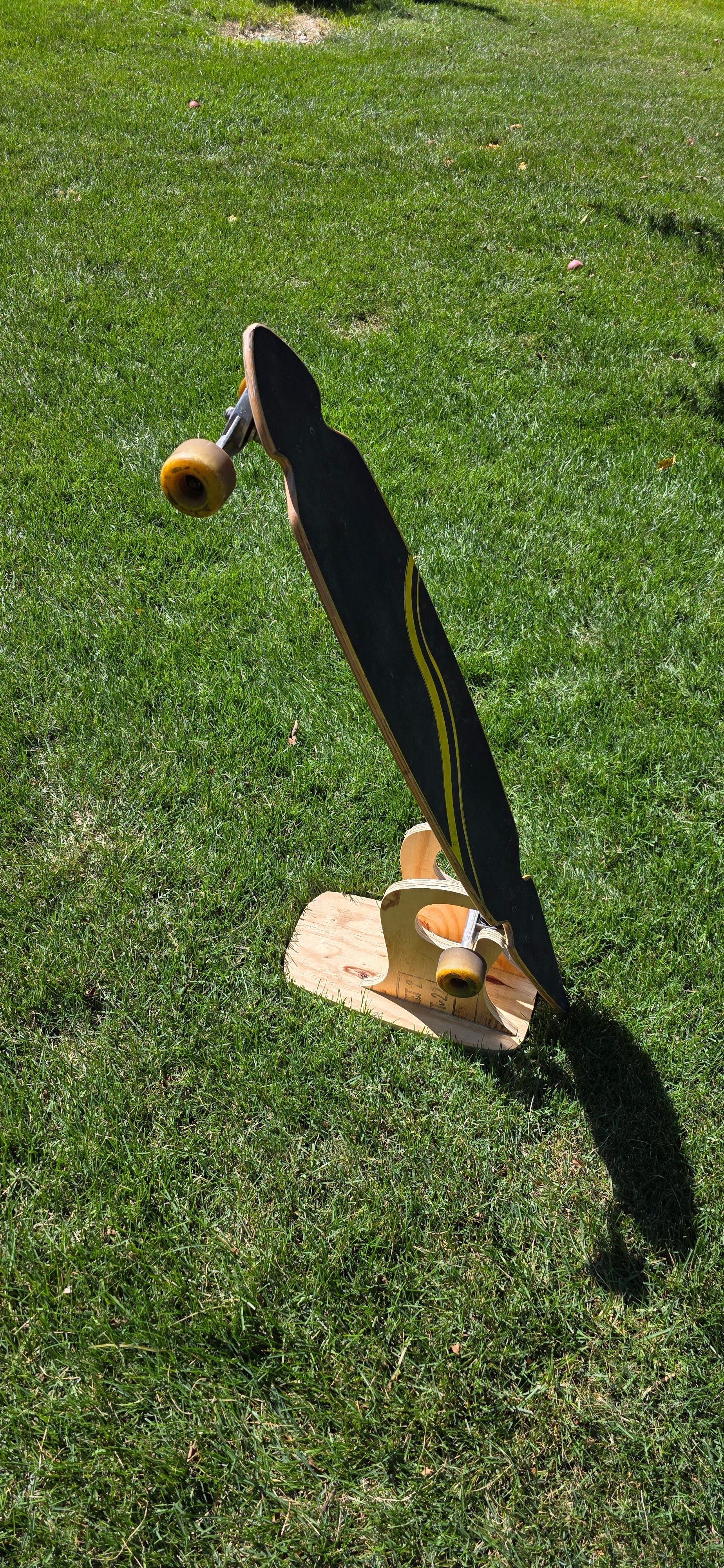 Construction Claw holding a longboard outside, displaying topside